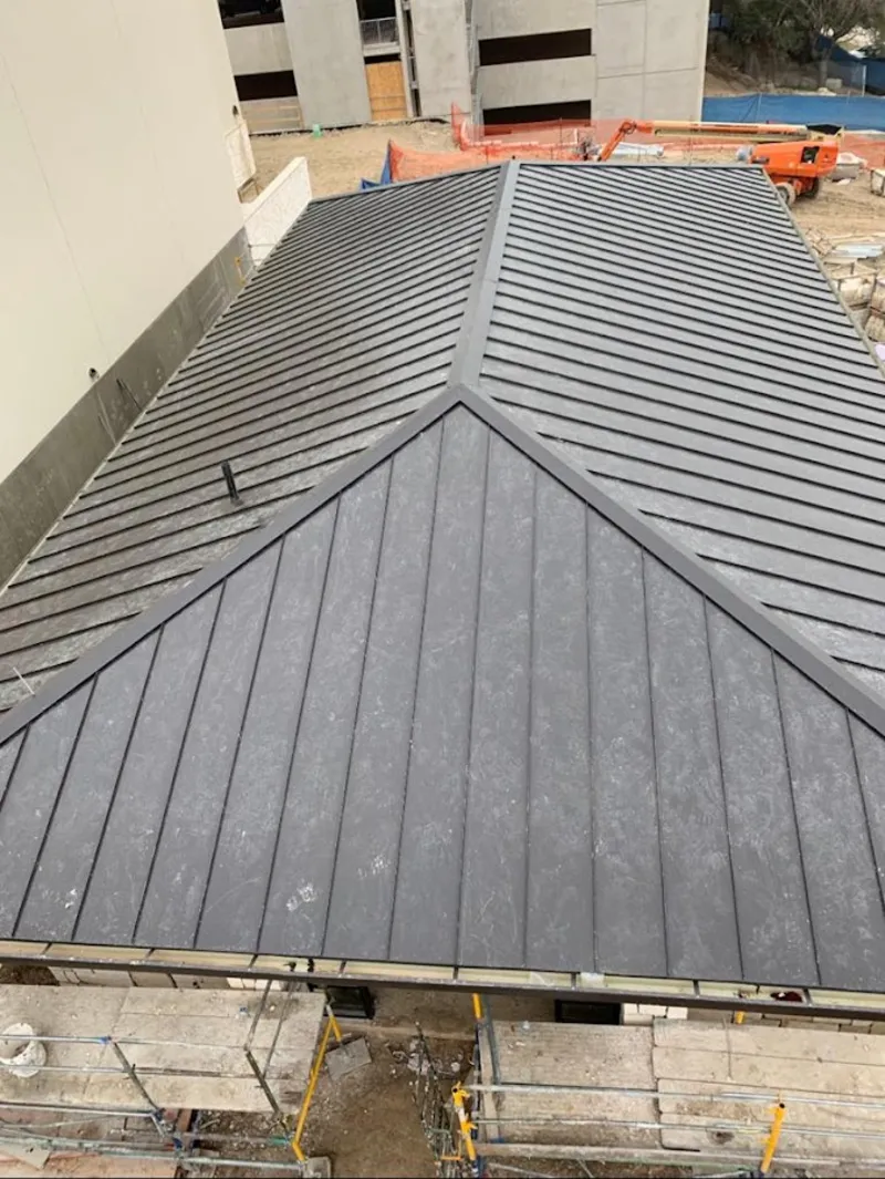 Commercial metal roof construction with crane equipment in North Hempstead